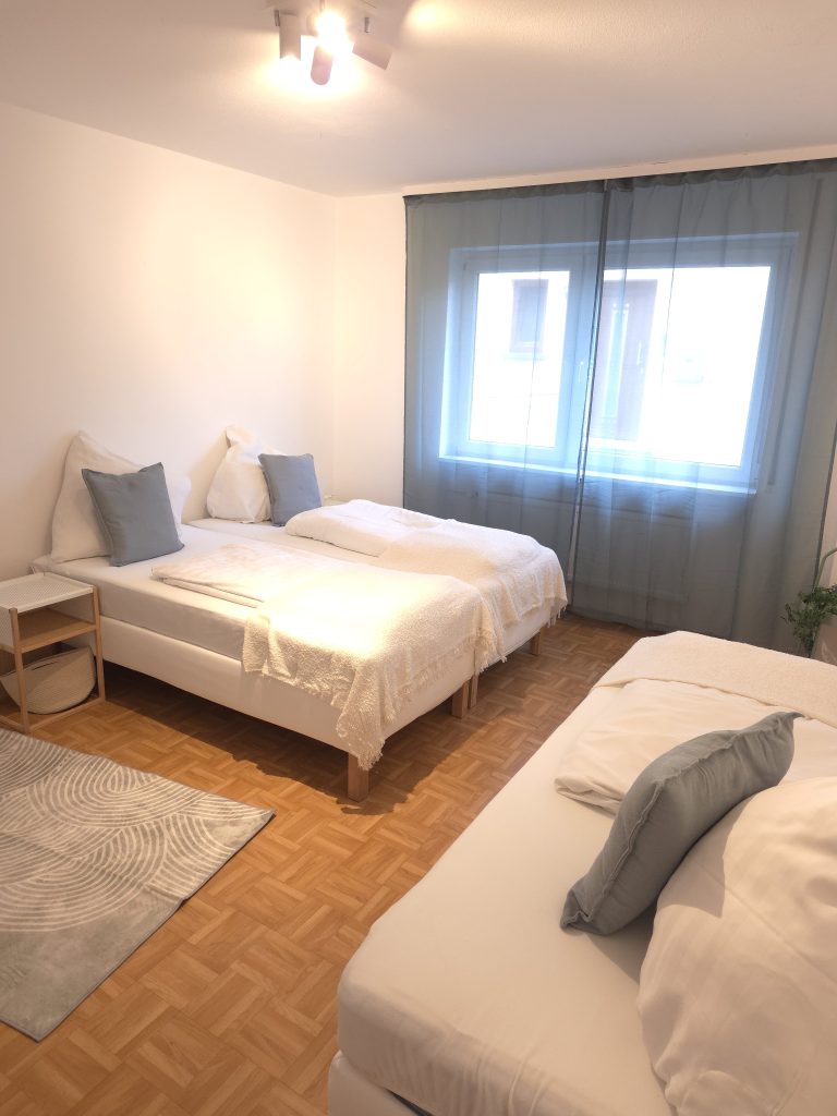 Schlafzimmer mit zwei Betten und Fenster