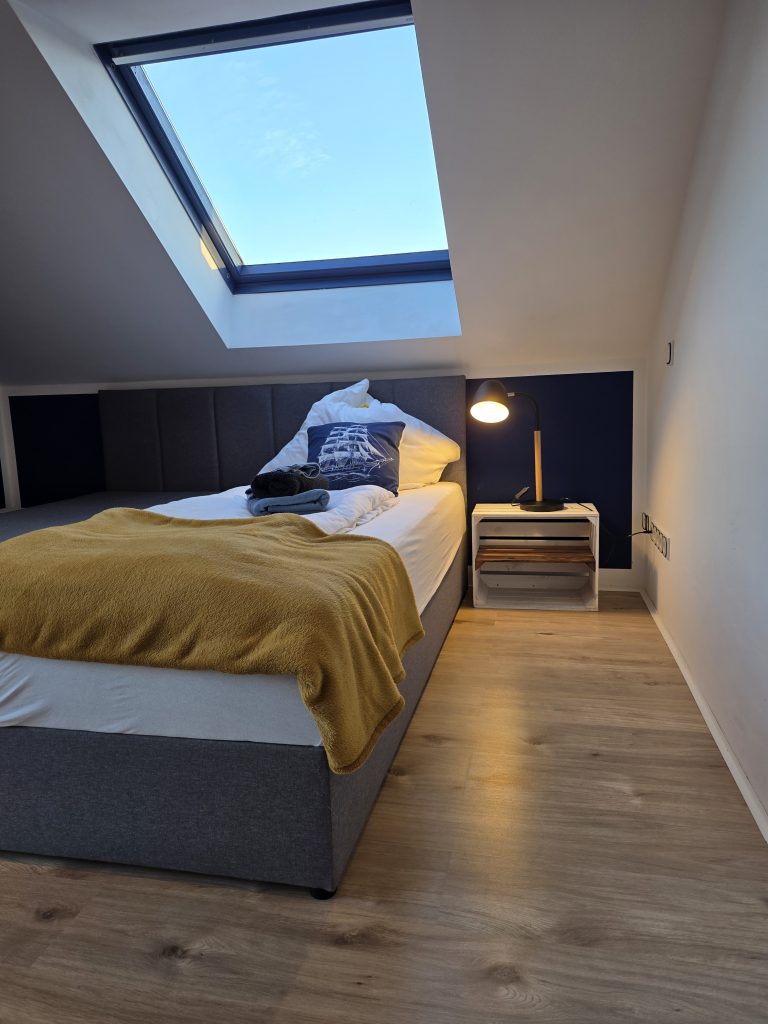 Zweites Schlafzimmer mit Boxspringbett und Nachttisch