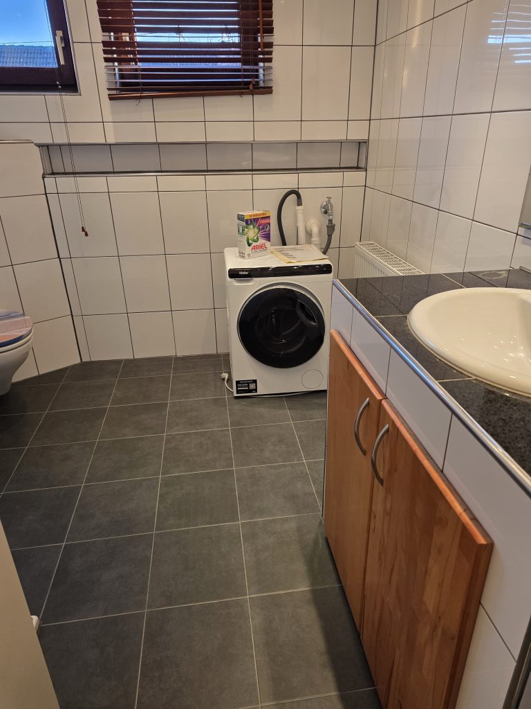 Bad mit Waschmaschine und Waschbecken