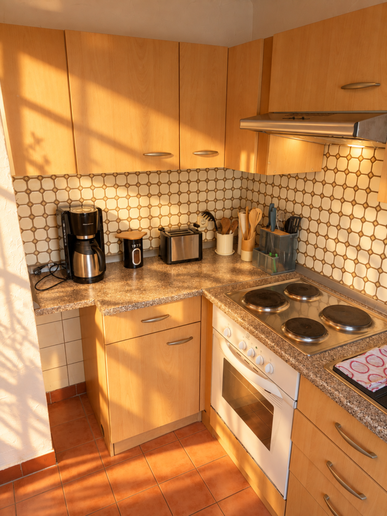 Küche mit Herd, Backofen und Kaffeemaschine