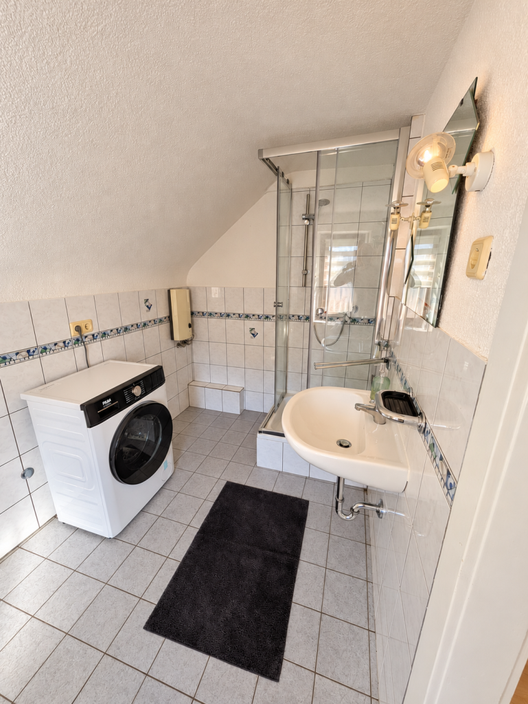 Bad mit Waschtrockner und Waschbecken