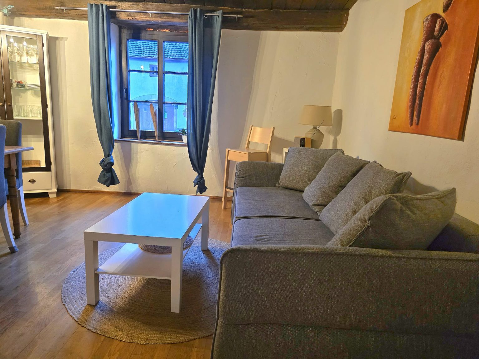 Sitzbereich mit Sofa und Couchtisch unter Holzbalkendecke