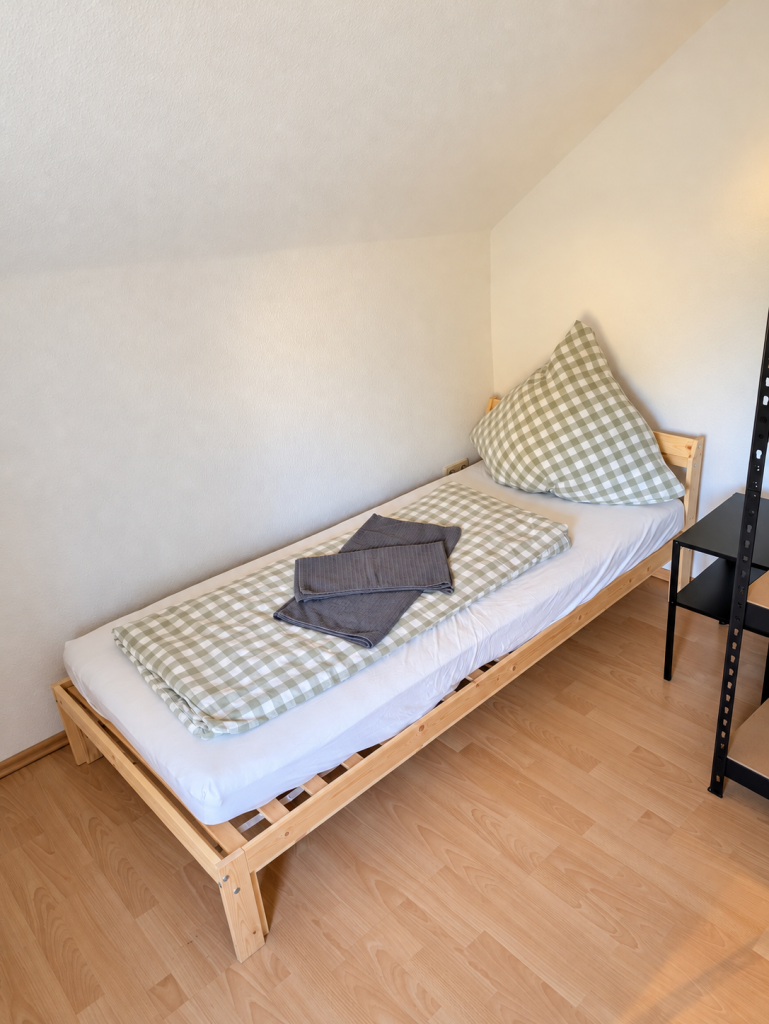 Schlafzimmer mit Einzelbett und Bettwäsche