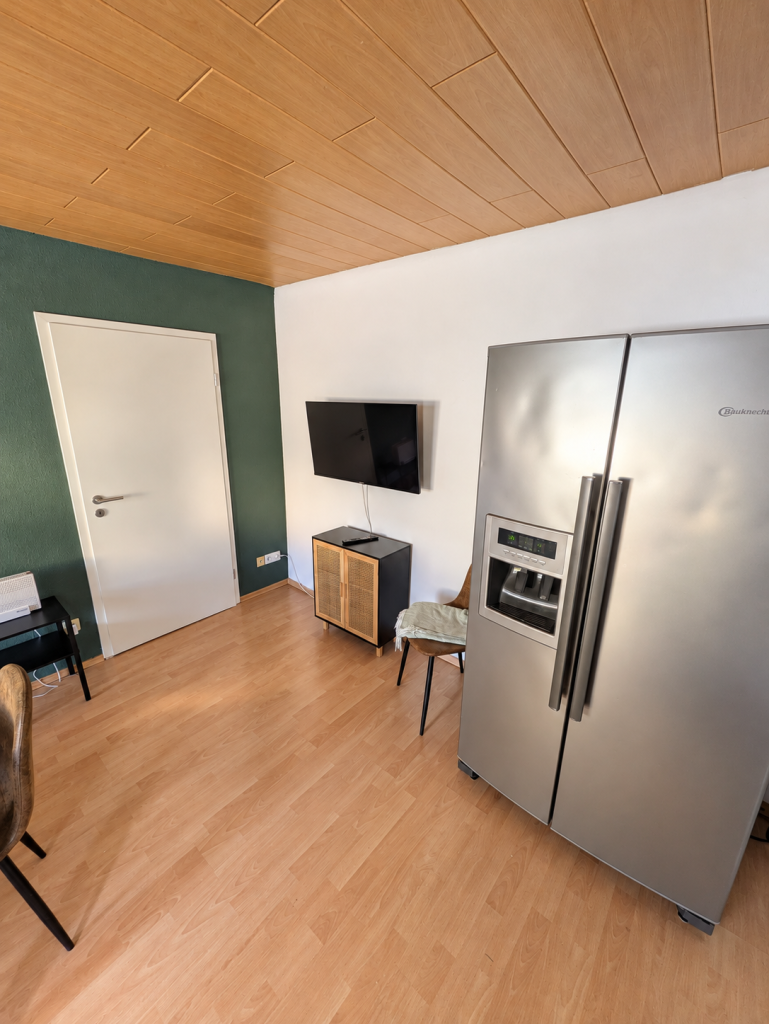 Essbereich mit Side-by-Side-Kühlschrank und Fernseher